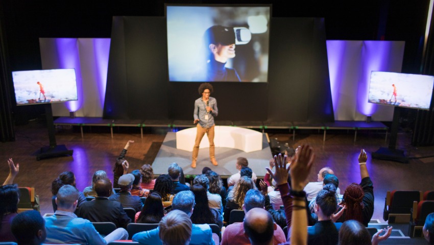 male speaker on stage answering audience questions picture id954610162